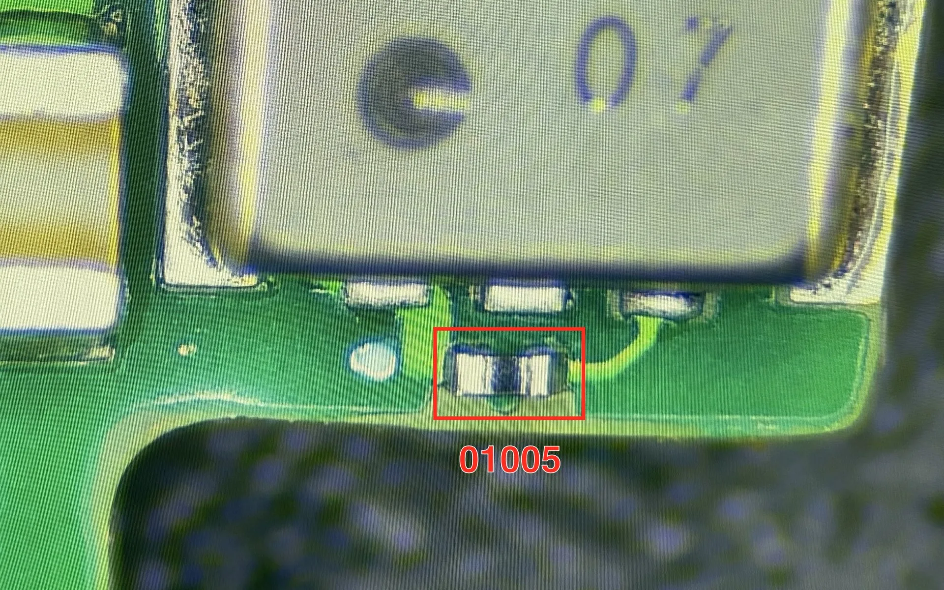 01005-component op een productieprintplaat onder de microscoop